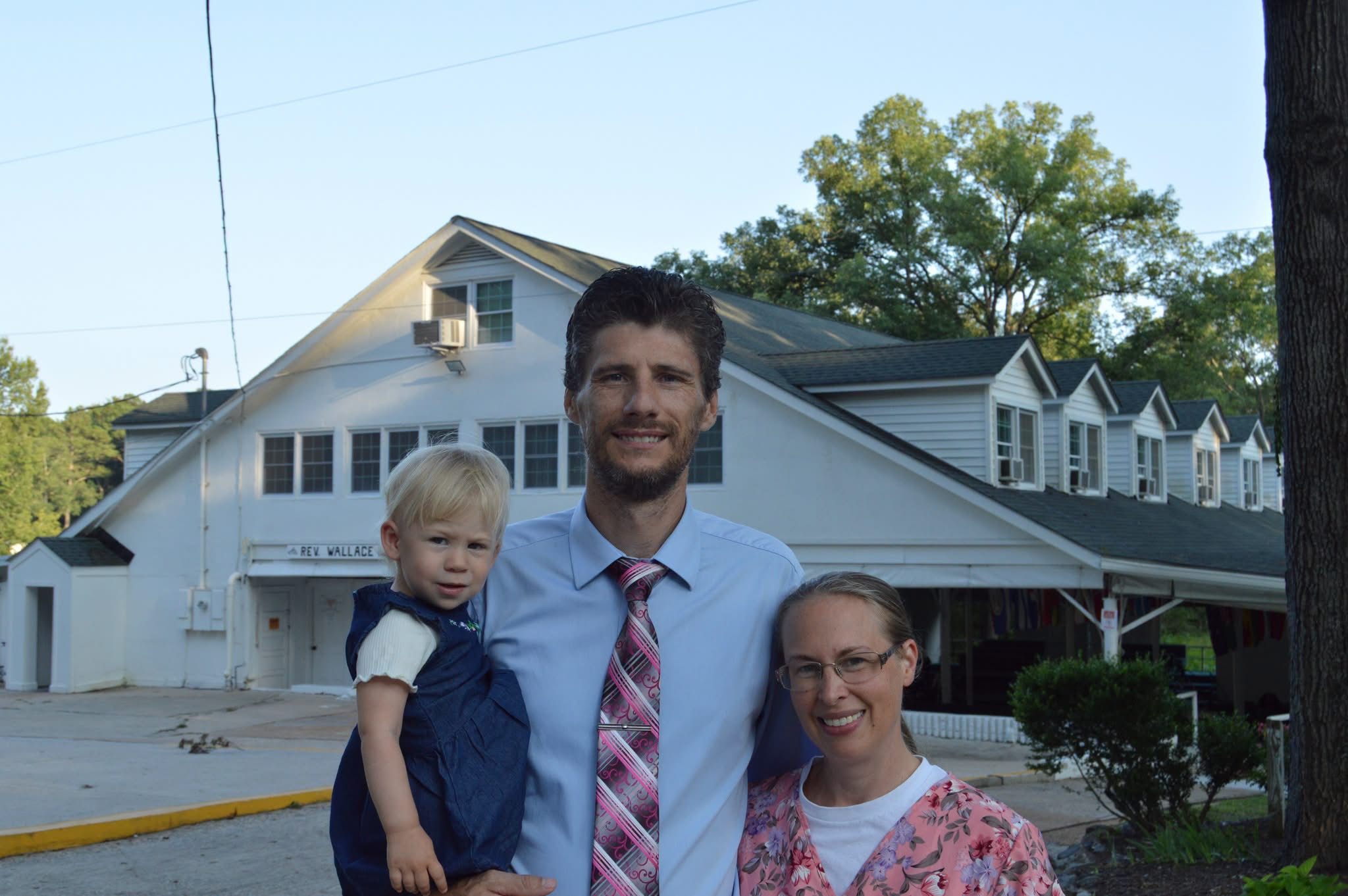 Rev. Billy and Angela McCalip with one of their children outside a church