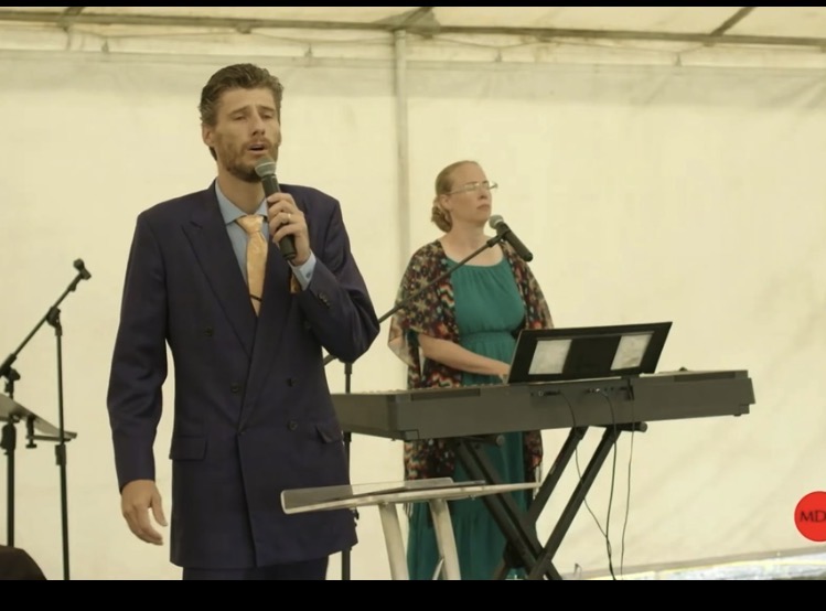 Billy McCalip singing while Angela McCalip accompanies at the keyboard